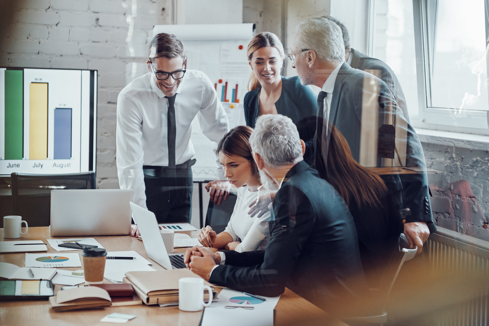 Successful business team analyzing sales while having staff meeting in the board room